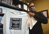 Need to read: Mary Howard-Hamilton holds one of the #FREEISU t-shirts being worn around the Indiana State University campus. She said social media has played a big role in bringing awareness to the effort on campus as well as what is going on at other colleges around the country. Staff photo by Jim Avelis