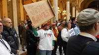 Crown Point resident Buffy Adams, carrying a homemade "Jesus Loves" sign, joined fellow supporters of legislation to expand the state's civil rights law to include sexual orientation and gender identity at the Statehouse Tuesday. Staff photo by Maureen Hayden