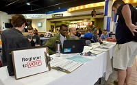 Sign in here: Indianapolis native a Indiana State University student Michael Shepard, center, works a voter registration booth in the school commons during the lunch hour Wednesday. Staff photo by Jim Avelis
