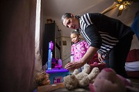Patricia Patterson, of South Bend, helps her 5-year-old daughter, Trishtan Lockett, on Thursday with some of the Christmas presents Patterson purchased with part of her JIFFI loan. Tribune Photo/MICHAEL CATERINA