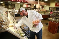 Craig Kirby restocks deli items Monday at the Lucky&rsquo;s Market on Bloomington&rsquo;s south side.&nbsp;Jeremy Hogan | Herald-Times