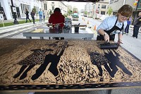 IUK Students and staff help each other make art prints from etchings using an asphalt roller to press muslin onto the printing plate on Friday, April 29, 2016. In front of the new IUK art gallery in the old Firestone building Libby Kimbrough rolls black ink on her printing plate. Staff photo by Tim Bath