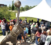 Johnny Wilson, right in tan jacket, is surrounded by well-wishers after the unveiing of the Jumpin' Johnny Wilson sculpture titled 'Far Reaching Goals' Friday in front of the Anderson High School entrance. Staff photo by John P. Cleary