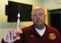 Clarksville Fire Department Chief Brandon Skaggs uses a water-filled syringe to demonstrate how firefighters would use Naloxone, a nasal spray used to reverse the effects of a drug overdose. Staff photo by Tyler Stewart