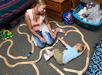 On one of her days off from working at Denny's, Josah Hollander plays Thomas the Train with her 2-year-old son Jay last week in their dorm-like room at the Evansville Goodwill Family Shelter. Staff photo by Mike Lawrence