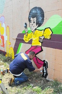 Artist Ish Muhammad spray-paints a cartoon caricature of Michael Jackson for the Jackson Five mural anniversary of his death. Muhammad and other Crazy Style Indiana Artists are displaying at the Indiana Staate Museum in downtown Indianapolis. Times file phto