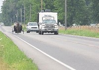 Vehicles pass an Amish buggy on S.R. 13 south of Middlebury. (Elkhart Truth photo / Sam Householder)