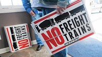 Visitors hand out "No Freight Trains" signs during a public meeting with the Surface Transportation Board on the proposed freight rail line that would run through Porter County. (Kyle Telechan / Post-Tribune)