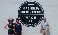 Busy place: Columnist Mark Bennett and his daughter, Mari, and Wife, Terri, pose beside sign for Magnolia Market and Garden in Waco, Texas, this month. The site is attracting 35,000 visitors a week this summer. Staff photo by Mark Bennett