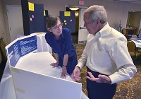  Explanations: Mary Jo Maraldo listens to Pat Martin&rsquo;s description of plans for the &ldquo;Turn to the River&rdquo; project. They were in the Hilton Garden Inn&rsquo;s Mayflower Room for the presentation Thursday. Staff photo by Jim Avelis