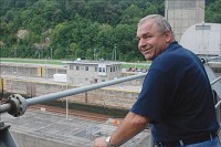 Atop the Cannelton dam, Lockmaster Kenny Schaefer has a view of just about the entire locks complex, including oncoming barge traffic. In the background is the powerhouse, the hub of operations, where lockmasters monitor and log vessels passing through the channel. Last year, more than 61 million tons of goods made its way through the cannelton site. Staff photo by Stuart Cassidy