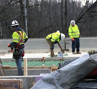 Construction workers labor between concrete barriers on Section 5 of the I-69 project in Bloomington on Feb. 14, 2017. Staff photo by Jeremy Hogan