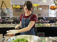 Shelby Pratt, a junior at Antioch College, chops vegetables in the dining hall on March 9, 2017. Pratt works full-time in the dining hall as part of Antioch's co-op program in which students hold full-time internships for a couple of months each year. This is Pratt's third co-op. Staff photo by Meghan Holden