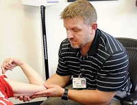 Dr. Andrew Skinner looks at a patient's arm where probuphine was implanted. Probuphune gives the patient a constant, low-level dose of buprenorphine over six months. Staff photo by Don Knight