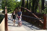 Ashley Nelson, Mike Baker and their two-year-old daughter, Sophii Baker cross over the Wildcat Creek as they walk along the Industrial Heritage Trail on Friday, June 2, 2017. Staff photo by Kelly Lafferty Gerber