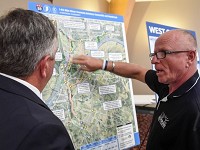 Darrell Littrell (right) talks with Ken Sperry about the two west routes for the proposed I-69 bridge crossing at the I-69 bridge route open house held at Milestones Crescent Room Monday. Littrell owns property along the routes and was concerned about placement and highway noise, July 31, 2017.&nbsp; Staff photo by Mike Lawrence
