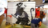 An original piece of Banksy art was delivered and installed for exhibit at the downtown Kokoko-Howard County Public Library on Aug. 3, 2017. Staff photo by Tim Bath