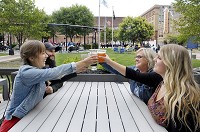 Taylor Cleveland, Ross Cleveland, Teena Hopkins and EMily Clark raise their glasses for a toast as they celebrate a birthday Friday evening on the patio of Kettletop Brewhouse in downtown Anderson as a concert goes on at the Dickmann Town Center. Staff photo by John P. Cleary