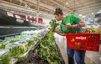 Coral Acosta, a Shipt shopper, picks out some kale while demonstrating the Shipt personal shopping at the Portage Road Meijer location in South Bend. Staff photo by Robert Franklin