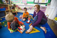 Program director Erin Crane plays with Joey Cabellero, center, and Destin Backus on Friday at South Bend's El Campito Child Development Center, which is among the pre-kindergarten providers in St. Joseph County that have been approved to accept children as part of the state's $22 million expansion of pre-k access for low-income families. Tribune Photo/MICHAEL CATERINA
