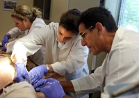 In July 2014, from left, Ashley Starcevich, of Lowell, Haley Nation, of Burr Ridge, Illinois, and Jose Mas, of Argentina, prepare a donor body for use in the classroom during the International Human Cadaver Prosection Program at the Indiana University School of Medicine-Northwest in Gary. The program has been cancelled after 18 years. Staff file photo by Jonathan Miano