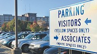 Signs posted in St. Vincent&rsquo;s parking lots direct employees to spaces farther from the building, to allow patients and visitors closer access. (IBJ photo/John Russell)