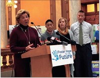 Sharon Pierce, president and CEO of The Villages family care center, left, explains the Indiana House of Representative&rsquo;s philanthropic campaign for the 2018 session. She&rsquo;s joined by 11-year-old A.J. Young and his adoptive parents, Karen and Weston Young. PHOTO BY SCOTT MILEY | CNHI NEWS SERVICE