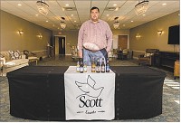 Aaron Scott, co-owner, vice president, and funeral director at Scott Funeral Home in Jeffersonville, stands behind a table with alcoholic beverages on it that can be served in their event room. Staff photo by Josh Hicks