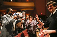 Protesters, including Vauhxx Booker holding megaphone, argue with Bloomington City Council member Steve Volan, right, after interrupting Mayor John Hamilton&rsquo;s State of the City speech Thursday at the Buskirk-Chumley Theater. Staff photo by Jeremy Hogan