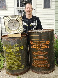 Tim Bowers found some old water cans and survival crackers while cleaning out a fallout shelter. Staff photo by John P. Cleary