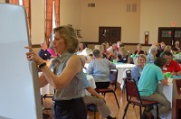 Terri Johnson of the Indiana Philanthropy Alliance writes on a whiteboard as participants in the Better Together meeting on Wednesday give their ideas on how to make Connersville a &ldquo;wow&rdquo; community. Staff photo by Bob Hansen