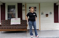 A handwritten sign on Tammy Breeding's front porch reads, "No loitering and prostituting in front of or around these premises. Violaters will be prosecuted." Breeding, a single mom, says she carries a gun to protect her family. Staff photo by Jonathan Miano