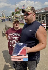 Doesn&rsquo;t see a problem: Ronald Brown Jr. holds a packaged Confederate flag that a friend bought for him on Monday at the Wabash Valley Fairgrounds. Brown said he would just hang it in his room and when asked why, said, &ldquo;I just like redneck things.&rdquo;Tribune-Star/Joseph C. Garza