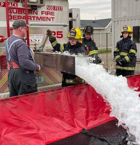 A cadet firefighter learns how to operate a dump valve on Auburn Fire Department's tanker truck during a training exercise. Auburn Fire Department photo