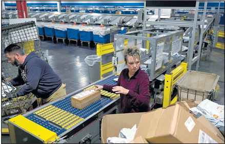 United States Postal Service clerks Jake Duke and Michelle Rogers load parcels onto the conveyor belt of the small delivery unit sorter Tuesday at the Terre Haute Sorting and Delivery Center on West Margaret Avenue. 
Tribune-Star/Joseph C. Garza