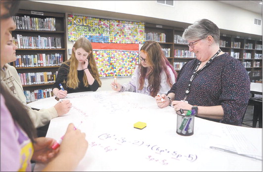 Maureen Beckwith, right, a paraprofessional at Western High School, works on math problems with students Thursday. Beckwith is part of the first cohort of paraprofessionals going back to school to become teachers through Ivy Tech Community College Kokomo. Kelly Lafferty Gerber | Kokomo Tribune